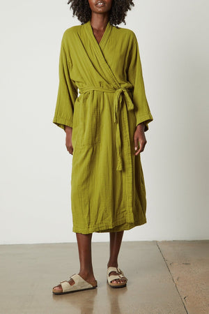 a woman wearing a green Cotton Gauze Robe from Jenny Graham Home and sandals.