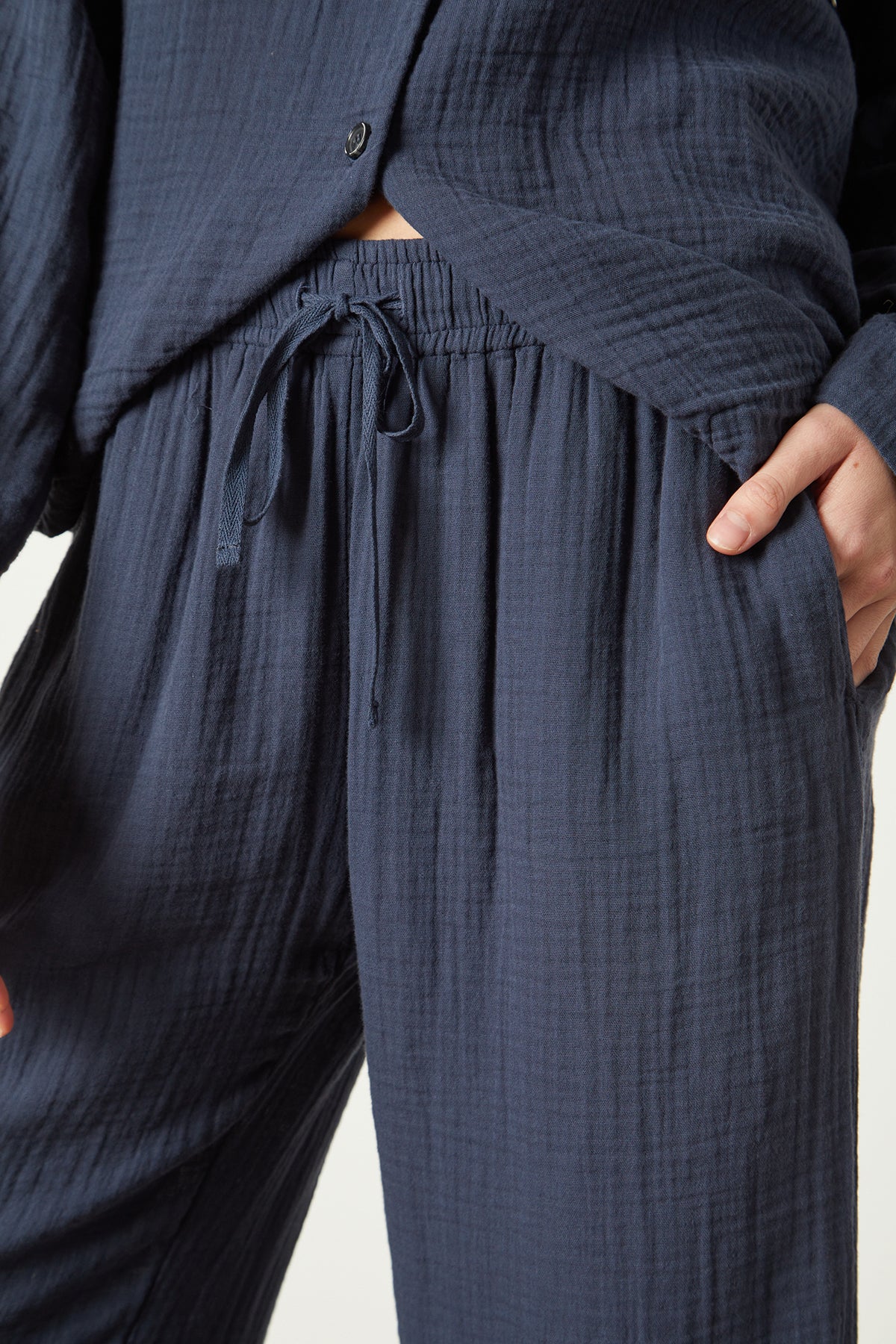   A woman wearing a dark blue Jenny Graham Home pajama pant. 