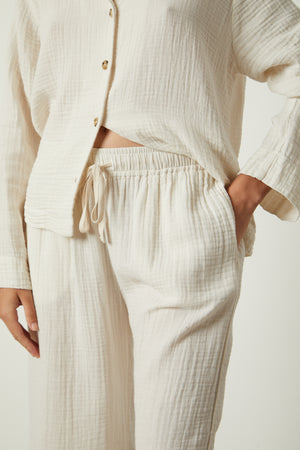 The model is wearing a white Jenny Graham Home Pajama Pant set.
