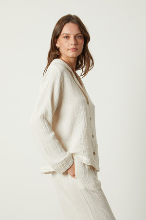 The model is wearing a white Jenny Graham Home pajama shirt and pants.