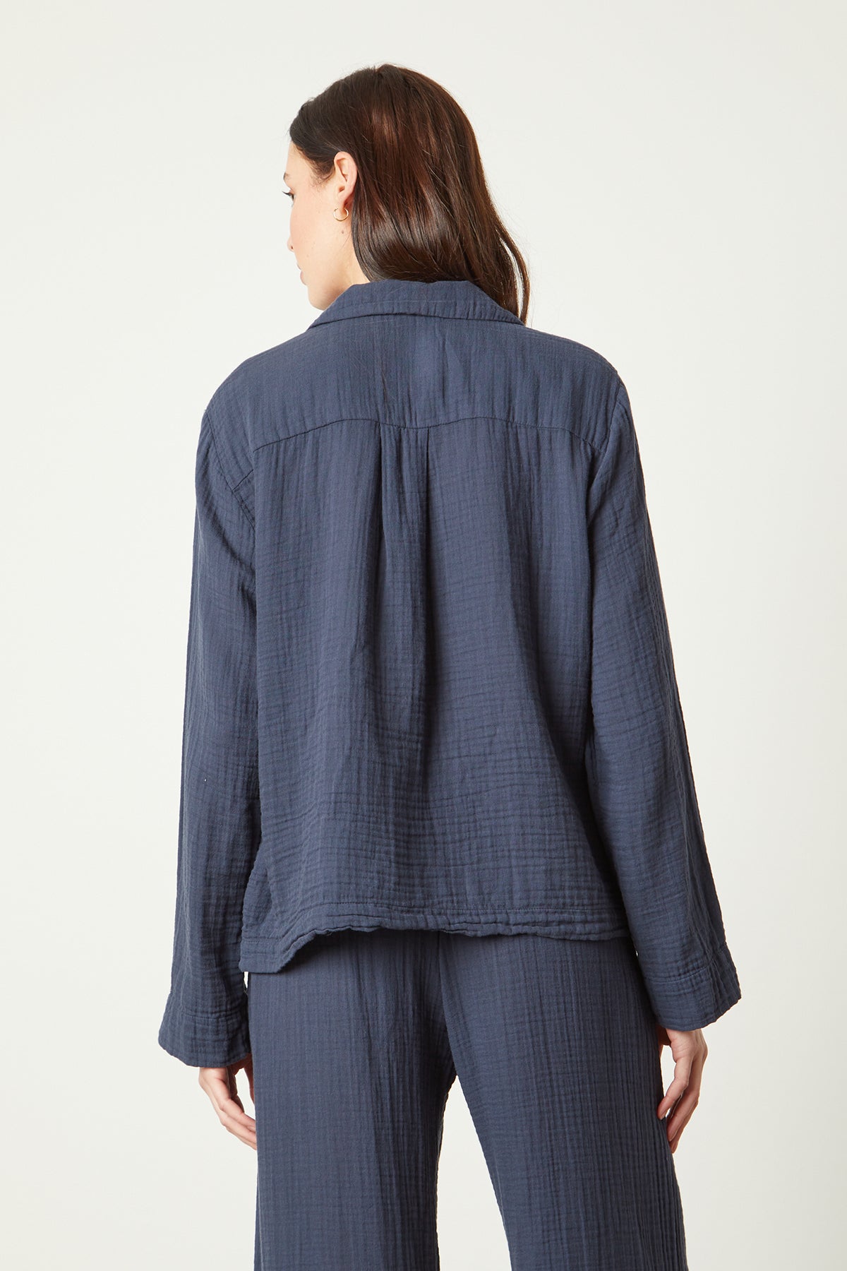 The back view of a woman wearing a blue linen PAJAMA SHIRT from Jenny Graham Home.-25519548137665