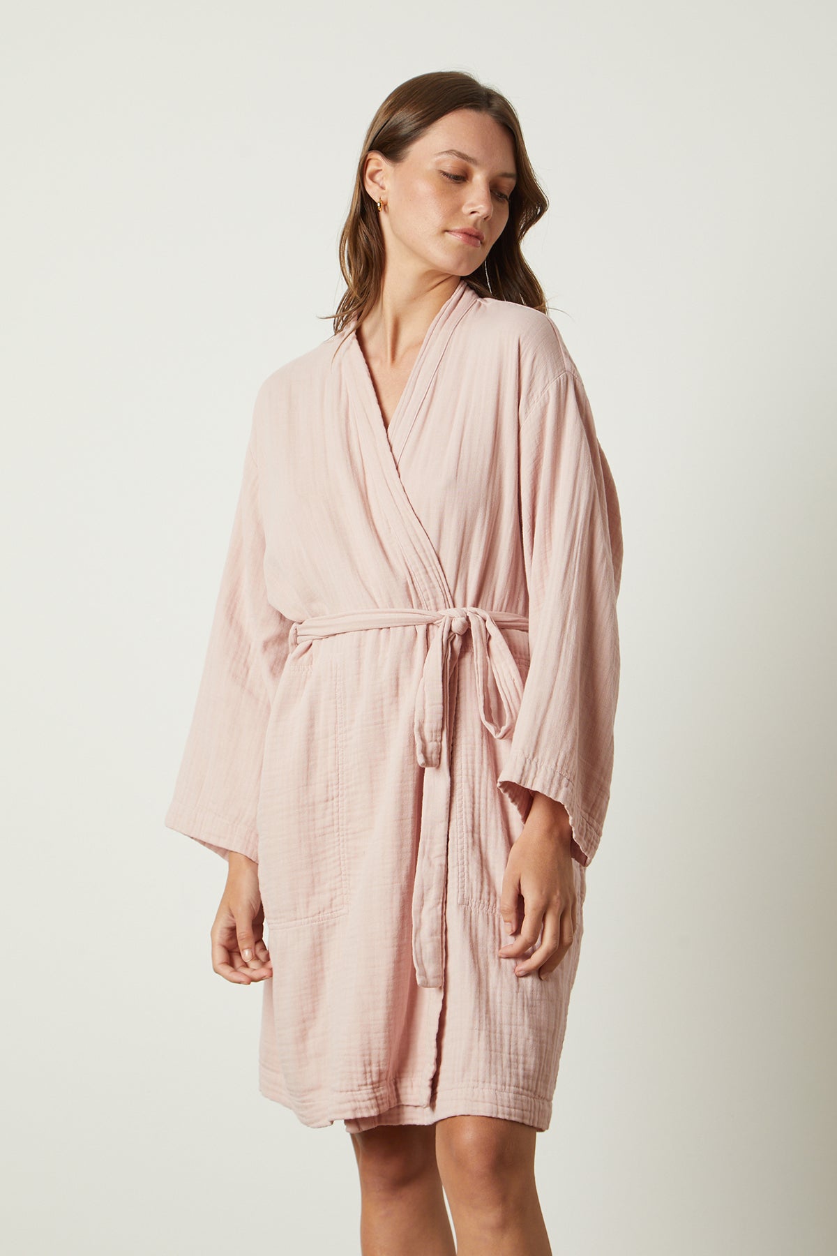   A woman wearing a mini thigh-length MINI COTTON GAUZE ROBE from Jenny Graham Home with a soft texture. 
