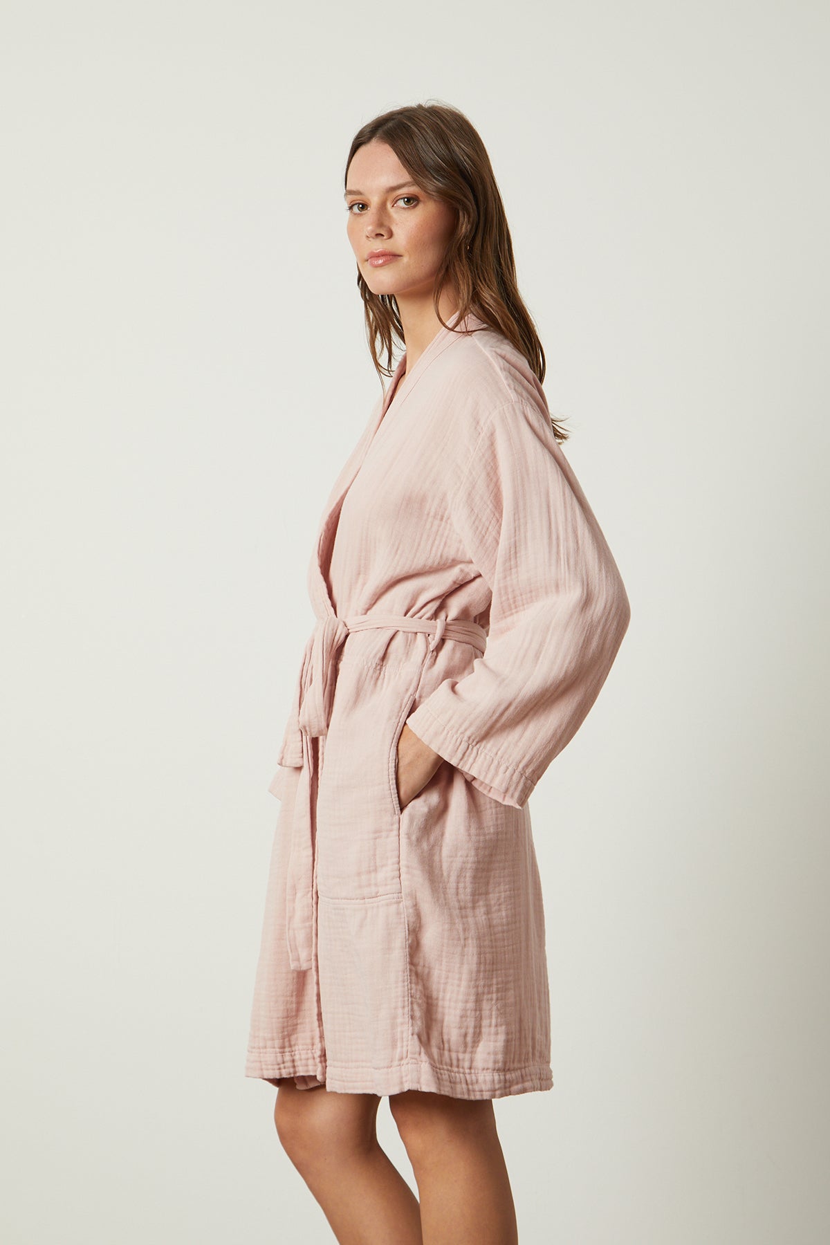 A woman wearing a soft texture pink MINI COTTON GAUZE ROBE by Jenny Graham Home.-25519664824513