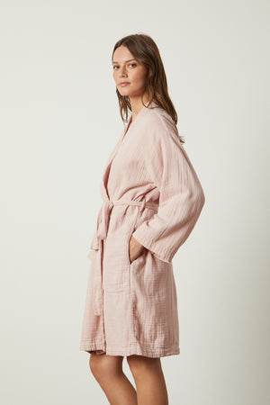 A woman wearing a soft texture pink MINI COTTON GAUZE ROBE by Jenny Graham Home.