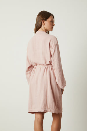 The back view of a woman wearing a MINI COTTON GAUZE ROBE by Jenny Graham Home.