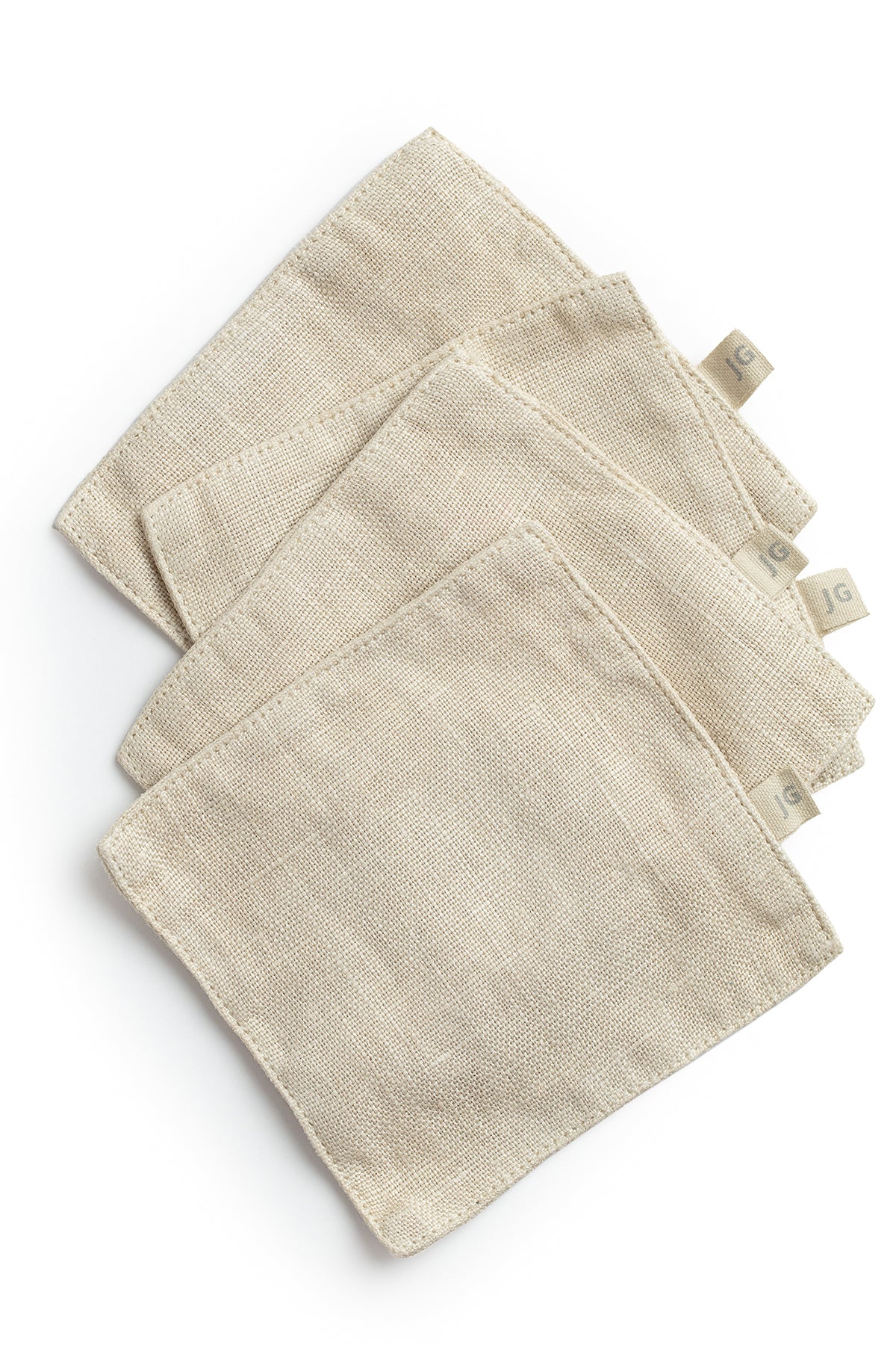 A set of four Jenny Graham Home Linen Coasters on a white surface.-15073230651585