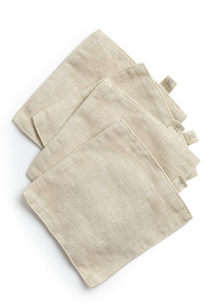 A set of four Jenny Graham Home Linen Coasters on a white surface.