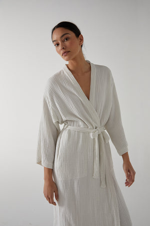 A woman wearing a Jenny Graham Home cotton gauze robe with a belt.