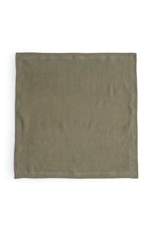 A green LINEN NAPKIN, an everyday kitchen essential, on a white background with a luxe finish from Jenny Graham Home.