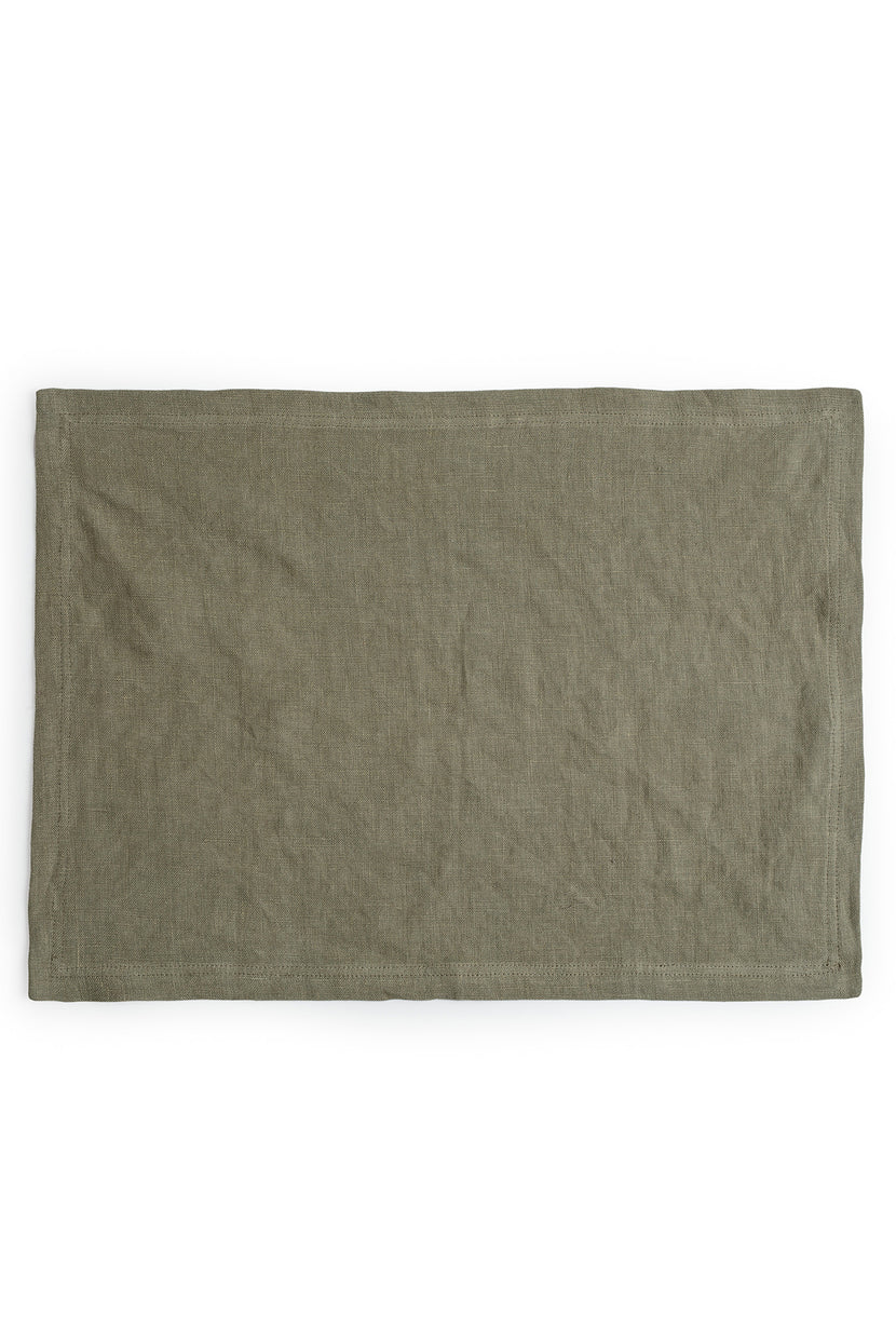 A plain green dyed Jenny Graham Home linen placemat displayed on a white background.