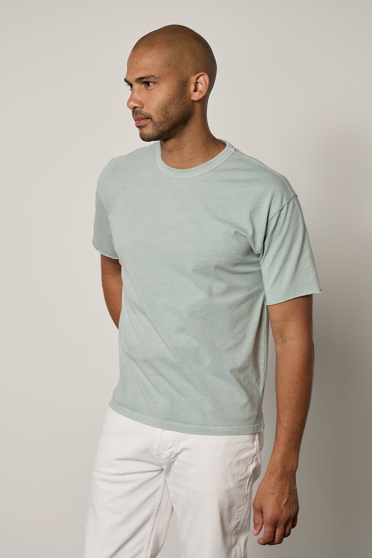   Man facing front wearing Beau Tee in mint green with white denim 