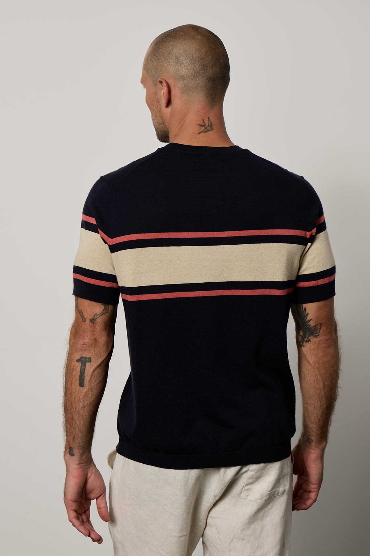   The back view of a man wearing a Velvet by Graham & Spencer Dexter Linen Blend Striped Crew sweater. 