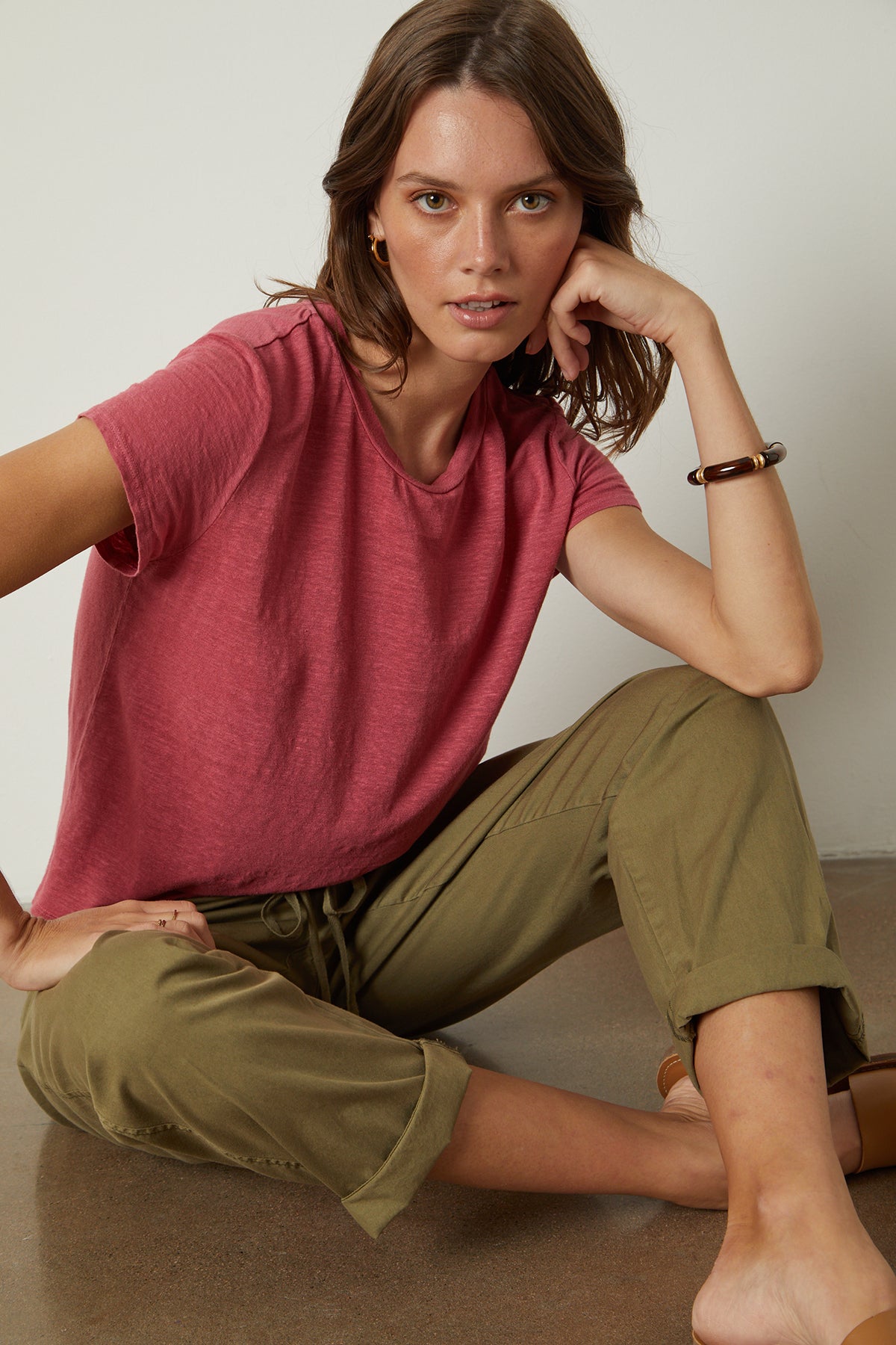   Model sitting cross legged on floor wearing Casey Tee in calypso with Misty pant in forest 