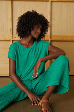 Model sitting wearing Lola linen pant and Hudson Tee in apple
