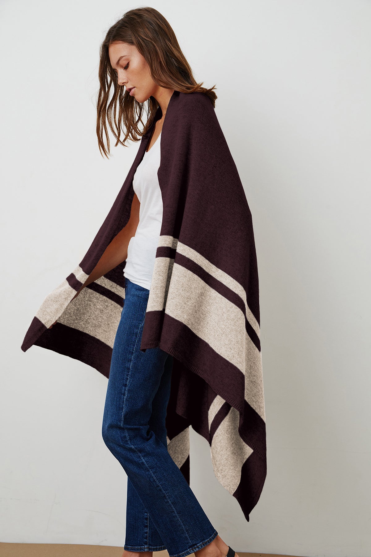   A cozy woman wearing a Jenny Graham Home LIV Cashmere Throw Blanket. 