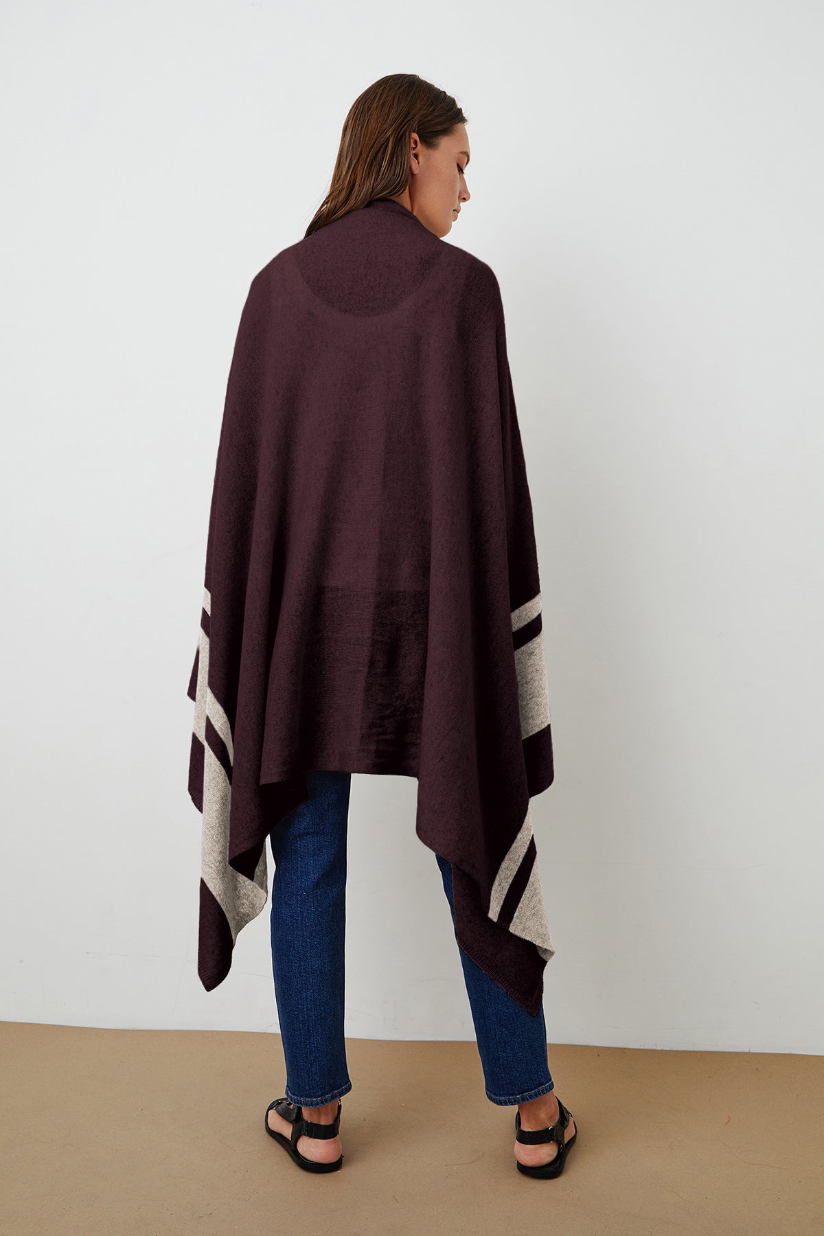 The back view of a woman wearing a Jenny Graham Home LIV CASHMERE THROW BLANKET poncho.-15274892525761