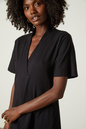 The model is wearing a black Velvet by Graham & Spencer NORA STRUCTURED DRESS.