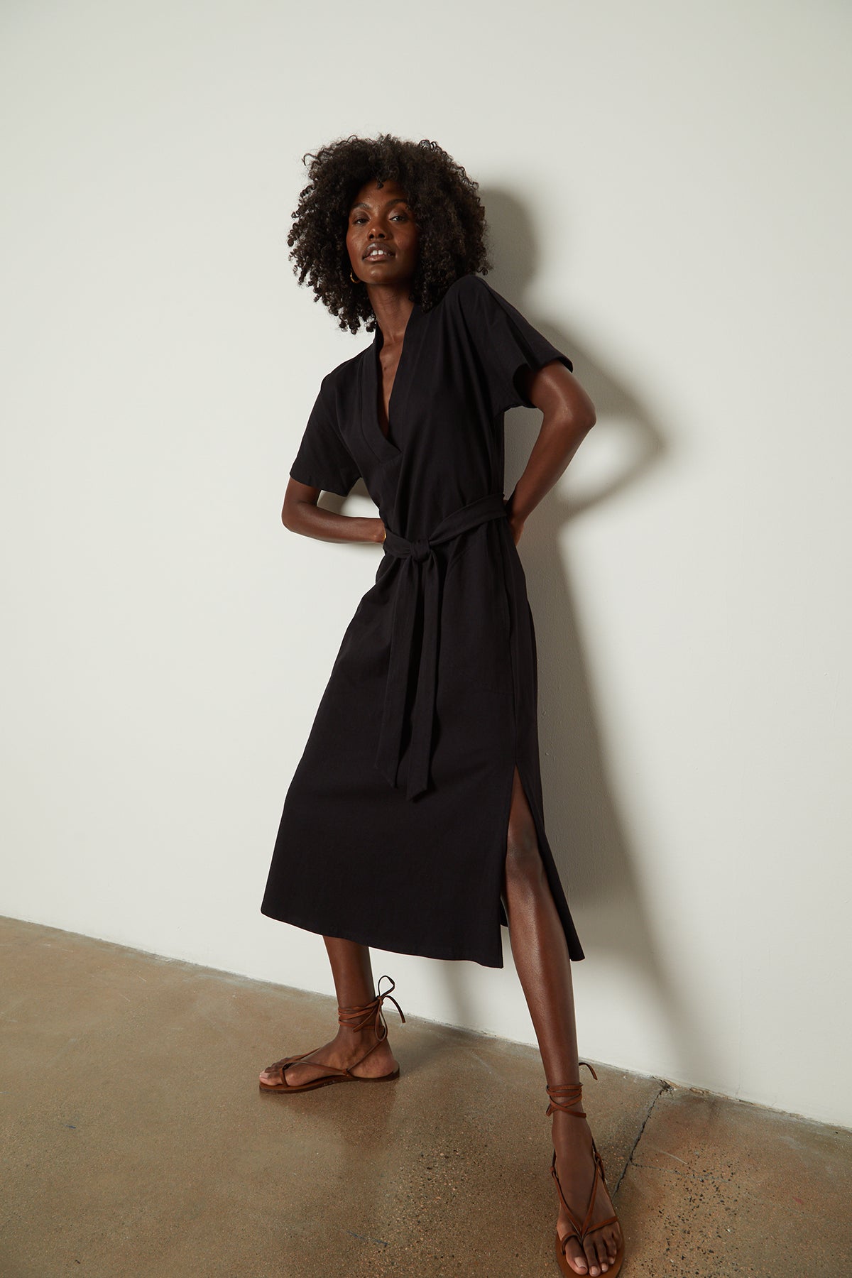   The model is wearing a black NORA STRUCTURED DRESS by Velvet by Graham & Spencer with a belt. 