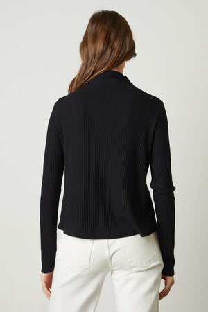 The back view of a woman wearing a Velvet by Graham & Spencer DEANNA MOCK NECK TOP.