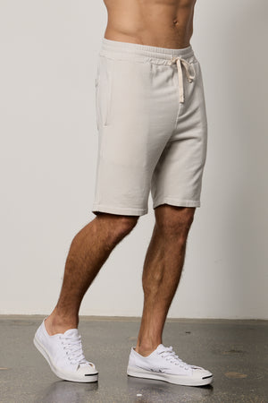 A man wearing a white tee shirt and Velvet by Graham & Spencer ATLAS LUXE FLEECE DRAWSTRING SHORT is always on heavy rotation.