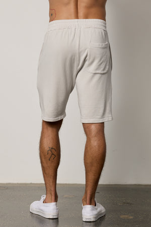 The ATLAS LUXE FLEECE DRAWSTRING SHORT by Velvet by Graham & Spencer create a timeless look for the back view of a man wearing grey sweat shorts.