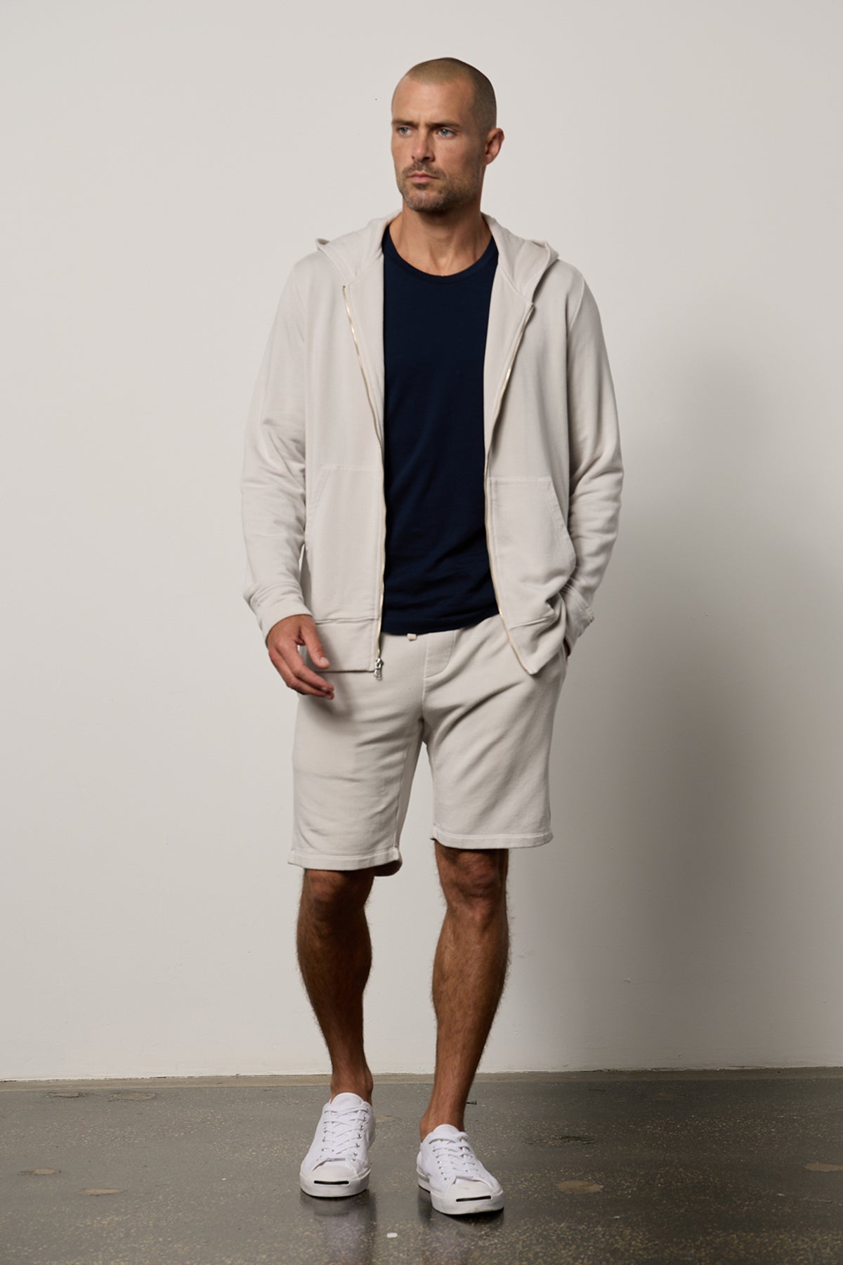 A man, always on heavy rotation, is wearing a Velvet by Graham & Spencer ATLAS LUXE FLEECE DRAWSTRING SHORT hoodie and classic-style shorts in beige.-26079123570881