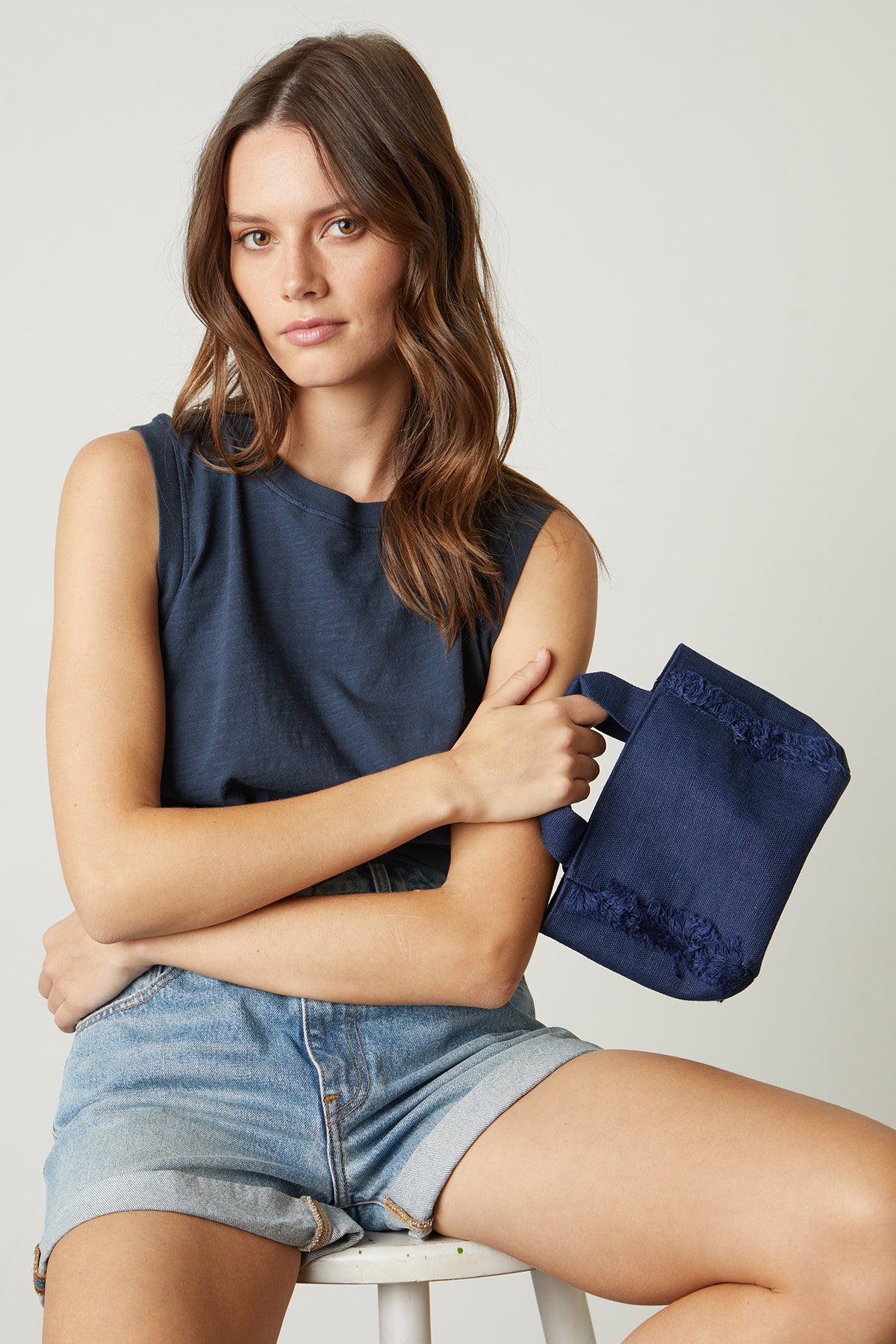 Mini Launch canvas tote in natural with model wearing navy tank and denim shorts-24659129270465