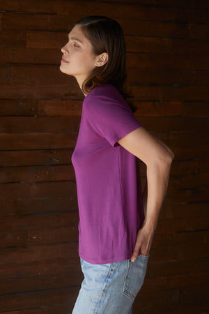 A woman wearing a Velvet by Jenny Graham SOLANA Tee purple t-shirt and jeans.