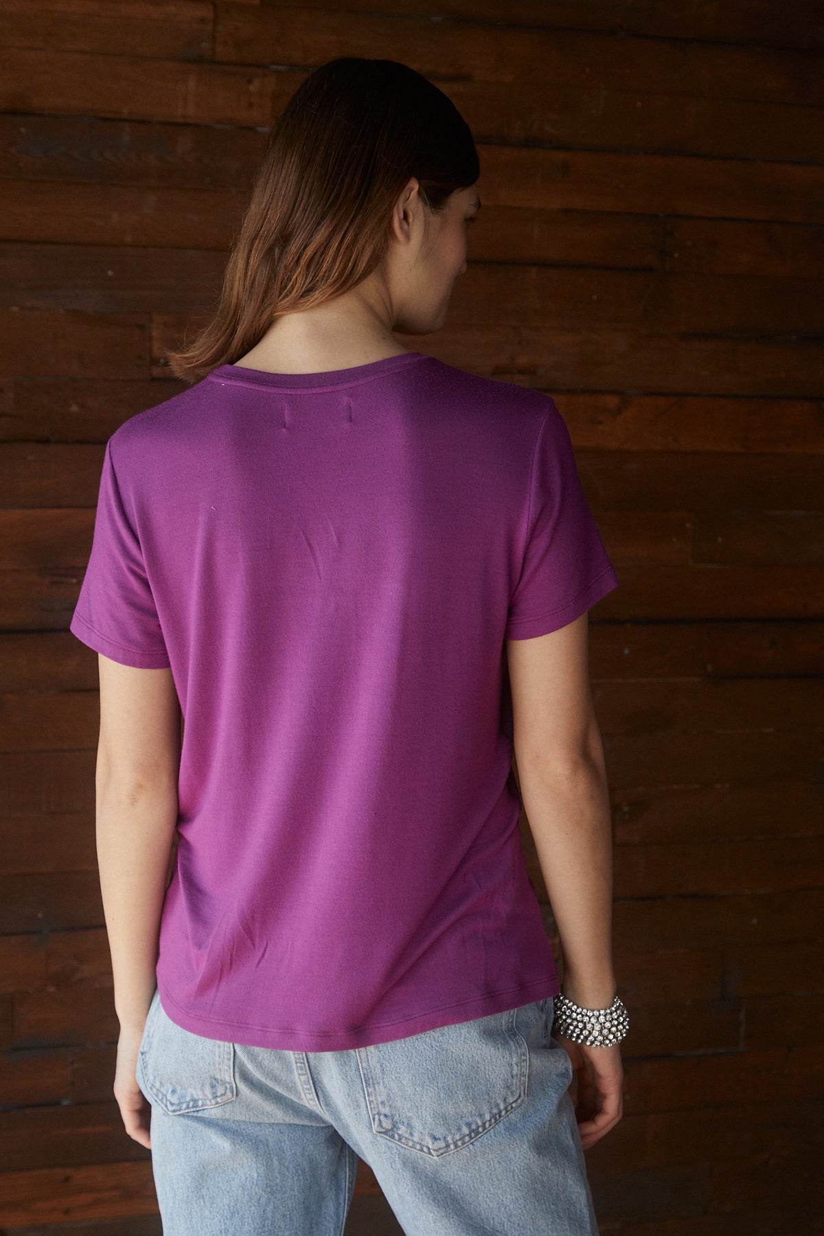   The woman, in a soft Velvet by Jenny Graham SOLANA TEE, showcases a tailored finish from the back. 