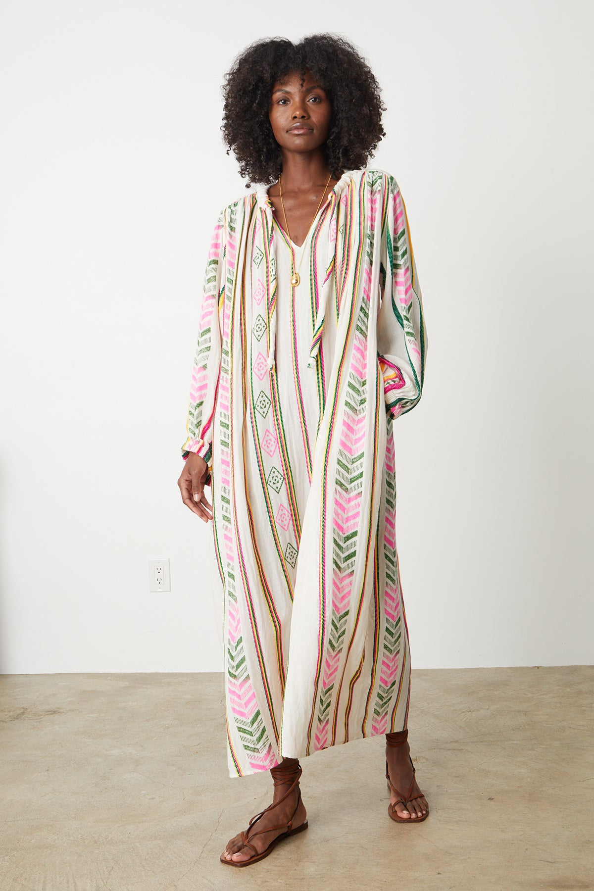  Peyton Maxi dress in multi colored jacquard full length front model taking step with hand in pocket. 