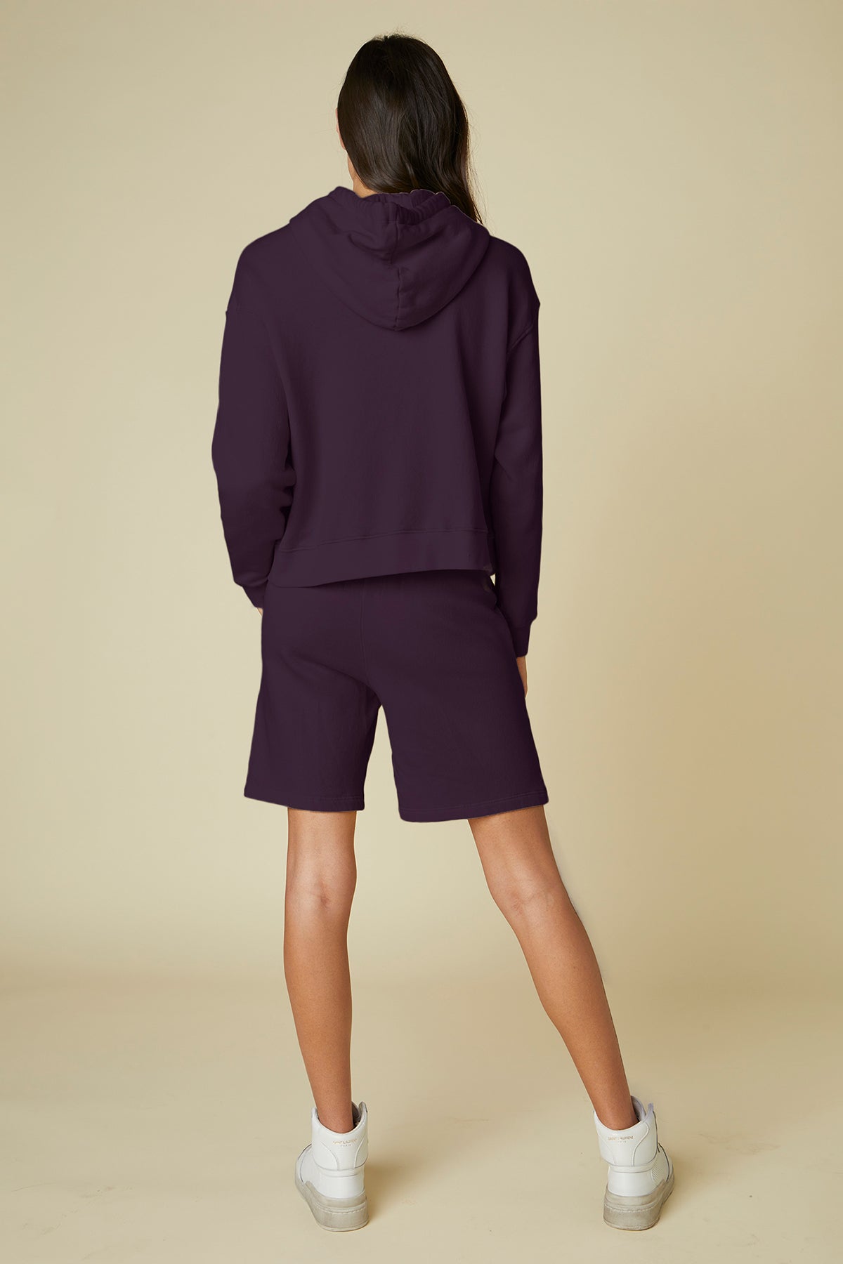 The back view of a woman wearing Velvet by Jenny Graham's LAGUNA SWEATSHORT with an elastic waist, paired with a purple hoodie.-24791114547393