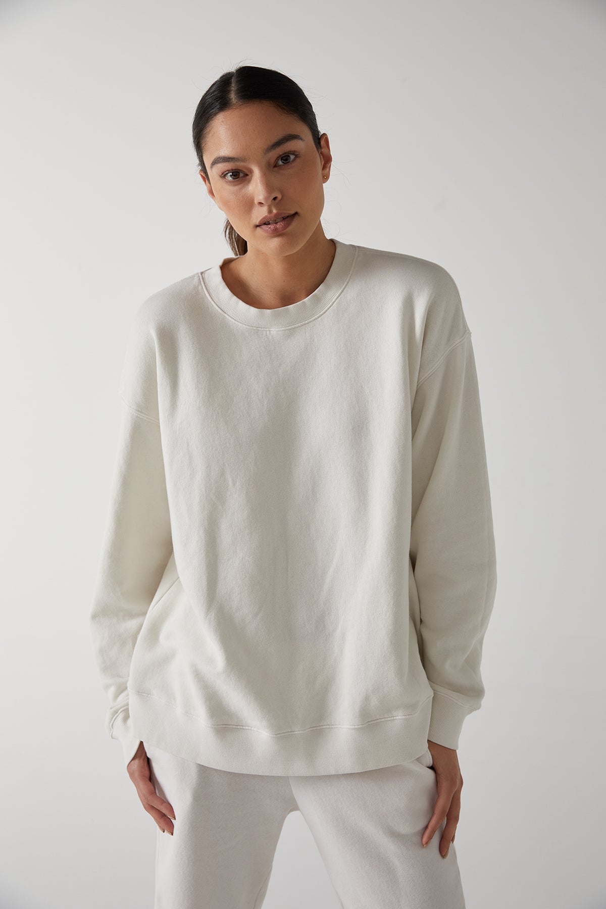   The model is wearing a slouchy white Abbot sweatshirt and sweatpants made from organic cotton by Velvet by Jenny Graham. 