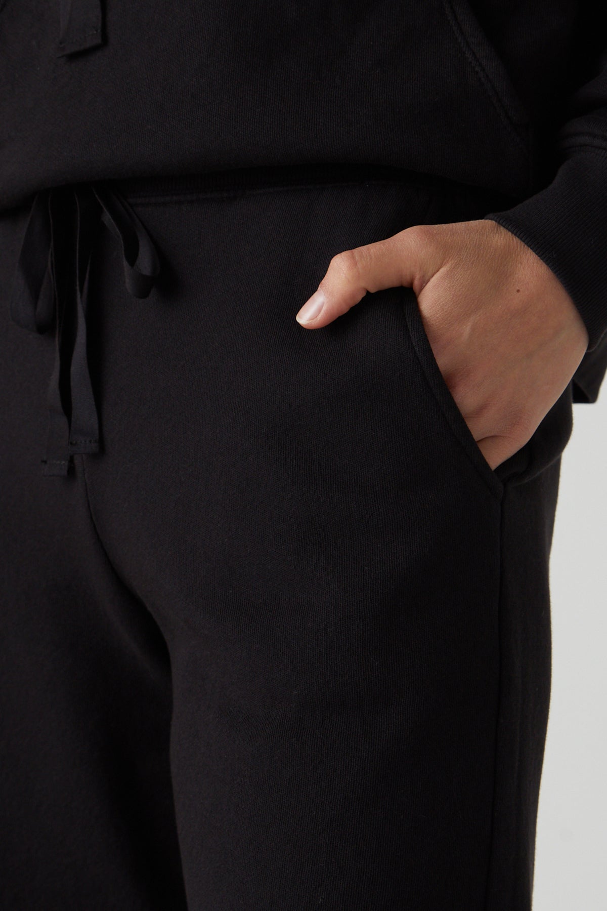 a woman wearing Velvet by Jenny Graham black sweatpants called LAGUNA SWEATSHORT and a hoodie.-25324534333633