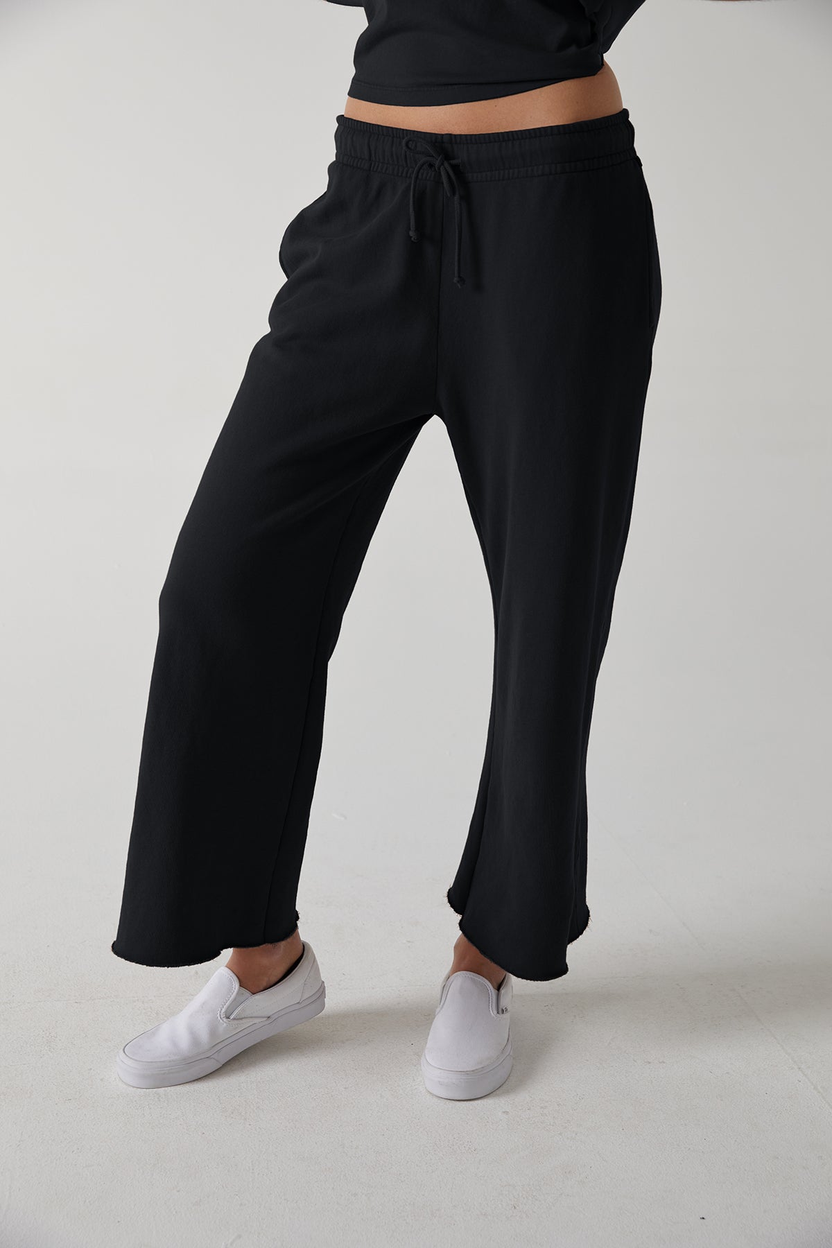 a woman wearing black Velvet by Jenny Graham Montecito sweatpants and a white t - shirt.-24331160715457