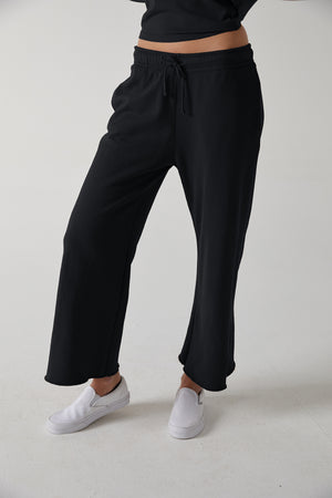 a woman wearing black Velvet by Jenny Graham Montecito sweatpants and a white t - shirt.