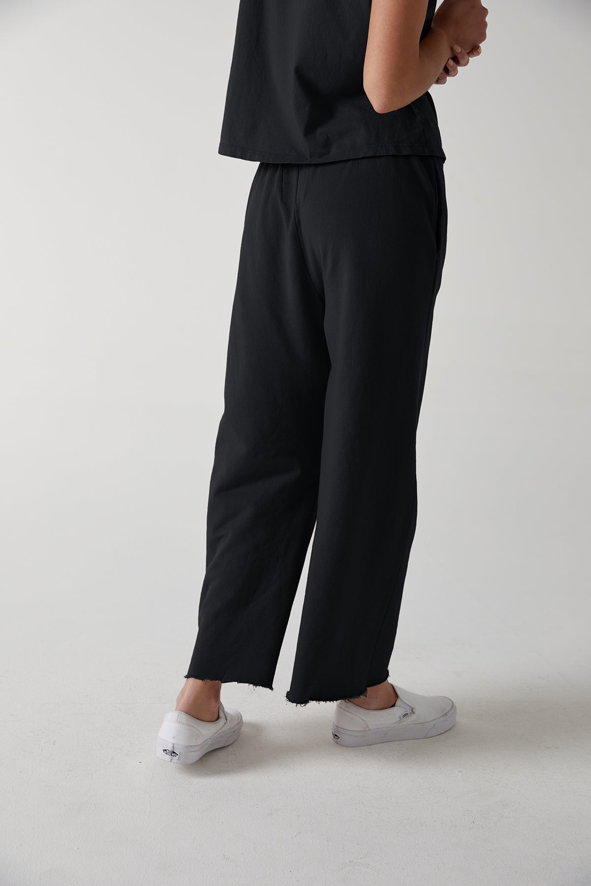 a woman wearing black Montecito sweatpants by Velvet by Jenny Graham and white sneakers.-24331160780993
