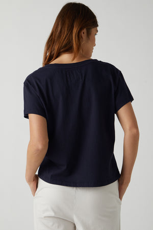 The back of a woman wearing a Velvet by Jenny Graham VENICE TEE and white pants.
