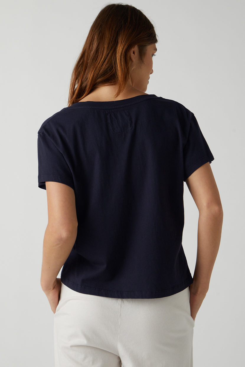 The back of a woman wearing a Velvet by Jenny Graham VENICE TEE and white pants.