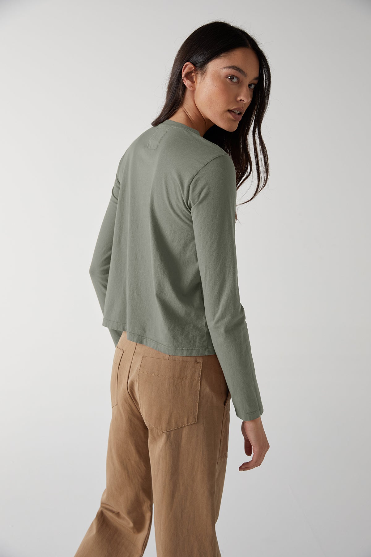   The back view of a woman wearing VICENTE TEE khaki pants and a long sleeved top by Velvet by Jenny Graham. 