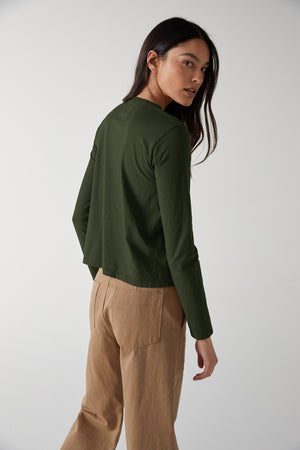 the back view of a woman wearing a Velvet by Jenny Graham VICENTE TEE and tan pants.