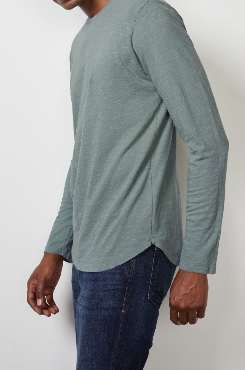a man wearing jeans and a green Velvet by Graham & Spencer CHANCE CREW NECK TEE.-14914192965825