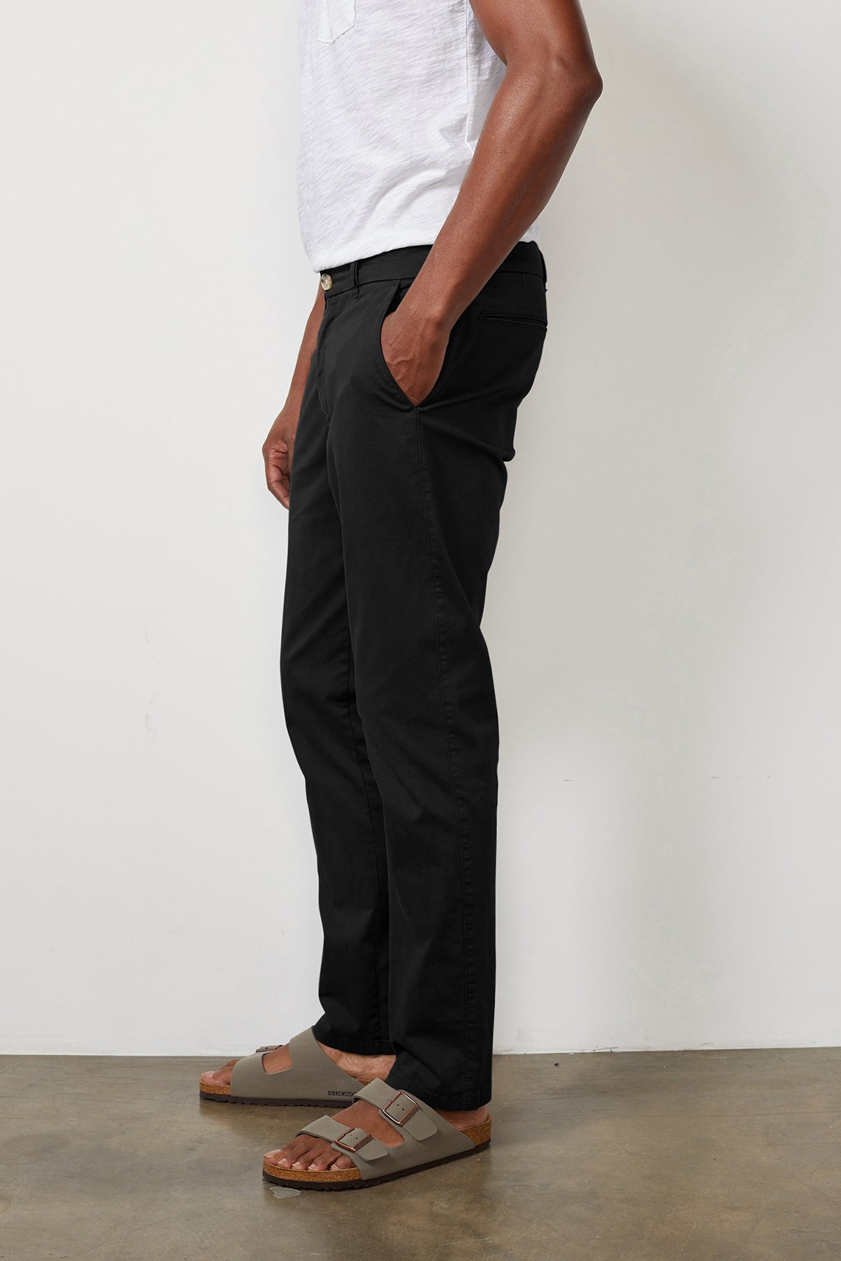 A man wearing a white t-shirt and Velvet by Graham & Spencer BROGAN COTTON TWILL PANT made of cotton twill.-7950531657809