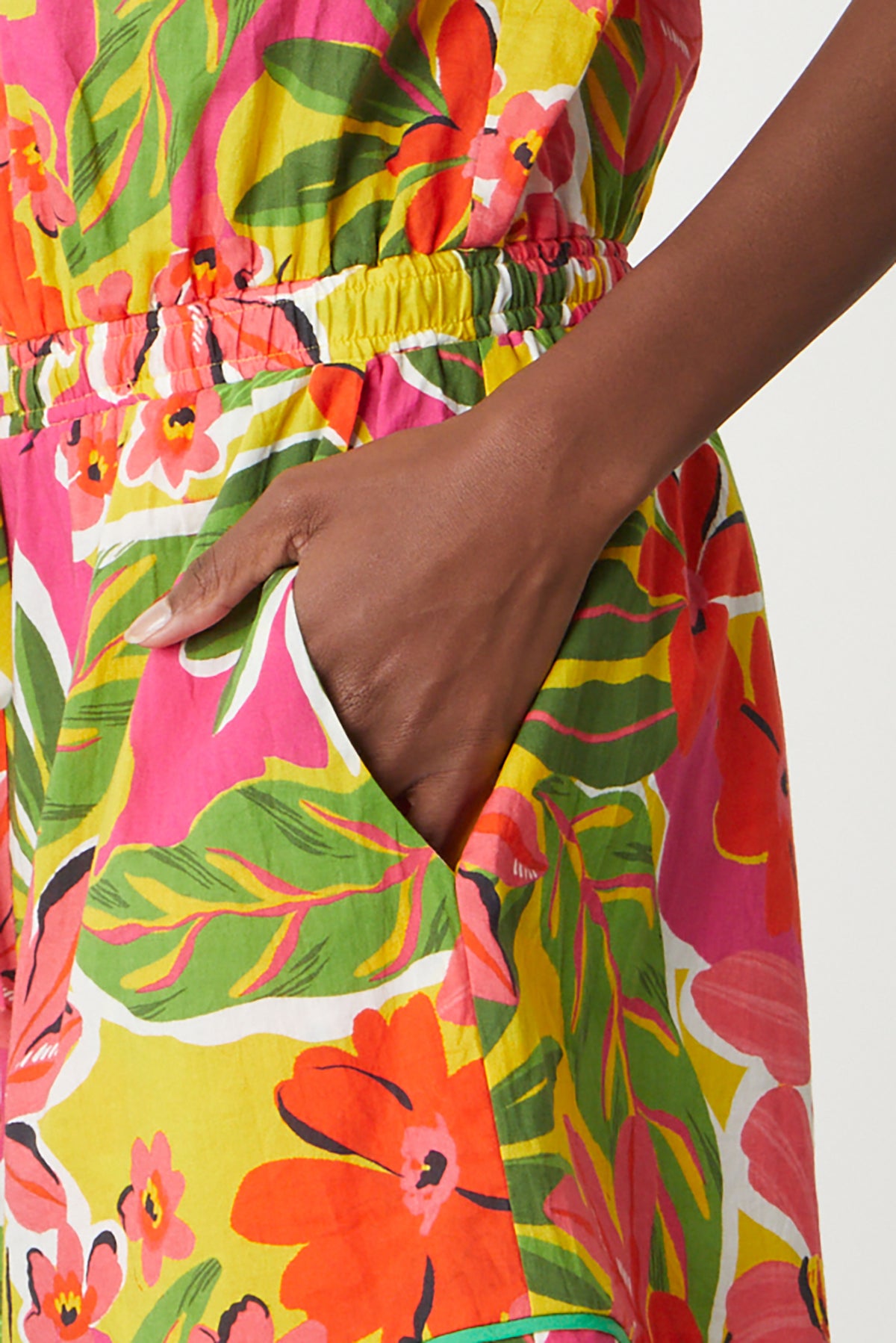   Pam Romper in bold floral aloha print with reds, hot pinks and greens detail of model's hand in pocket close up 