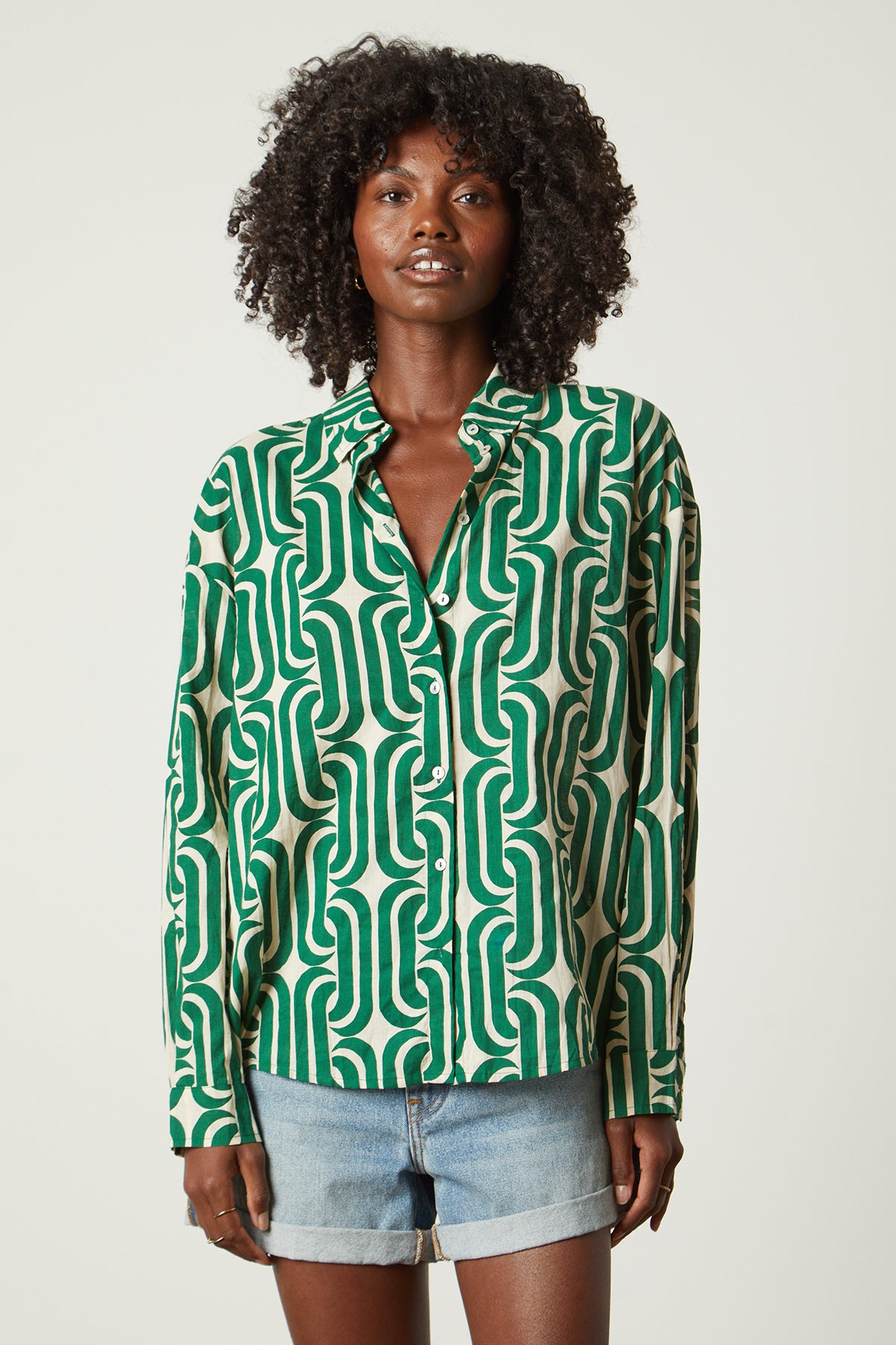 The model is wearing a Velvet by Graham & Spencer ANNALISE PRINTED TOP with a geometric pattern.-26142518542529