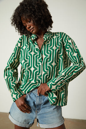 a woman wearing a green ANNALISE PRINTED TOP by Velvet by Graham & Spencer shirt and shorts.