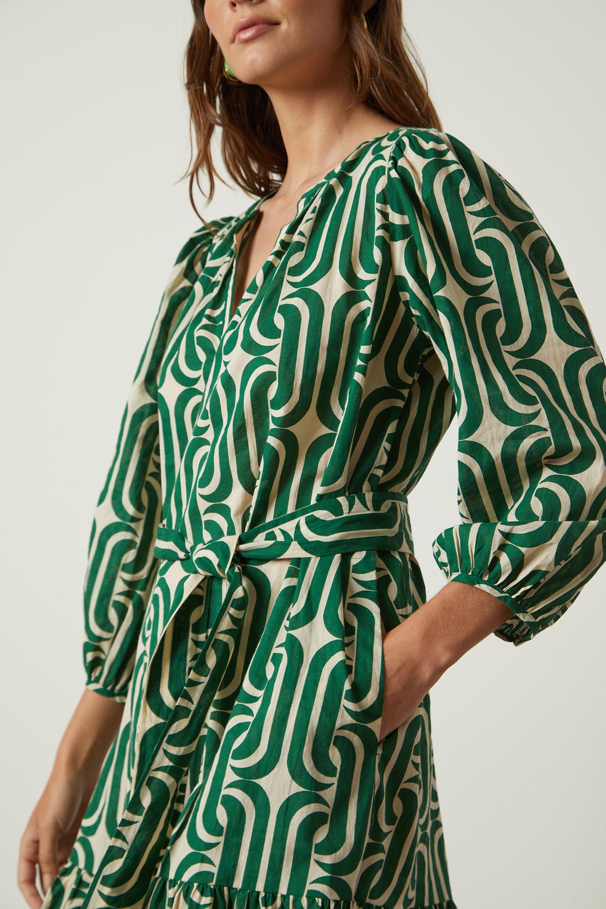 The model is wearing a Velvet by Graham & Spencer FELICITY PRINTED BOHO DRESS with a ruffled hemline.-26142628446401