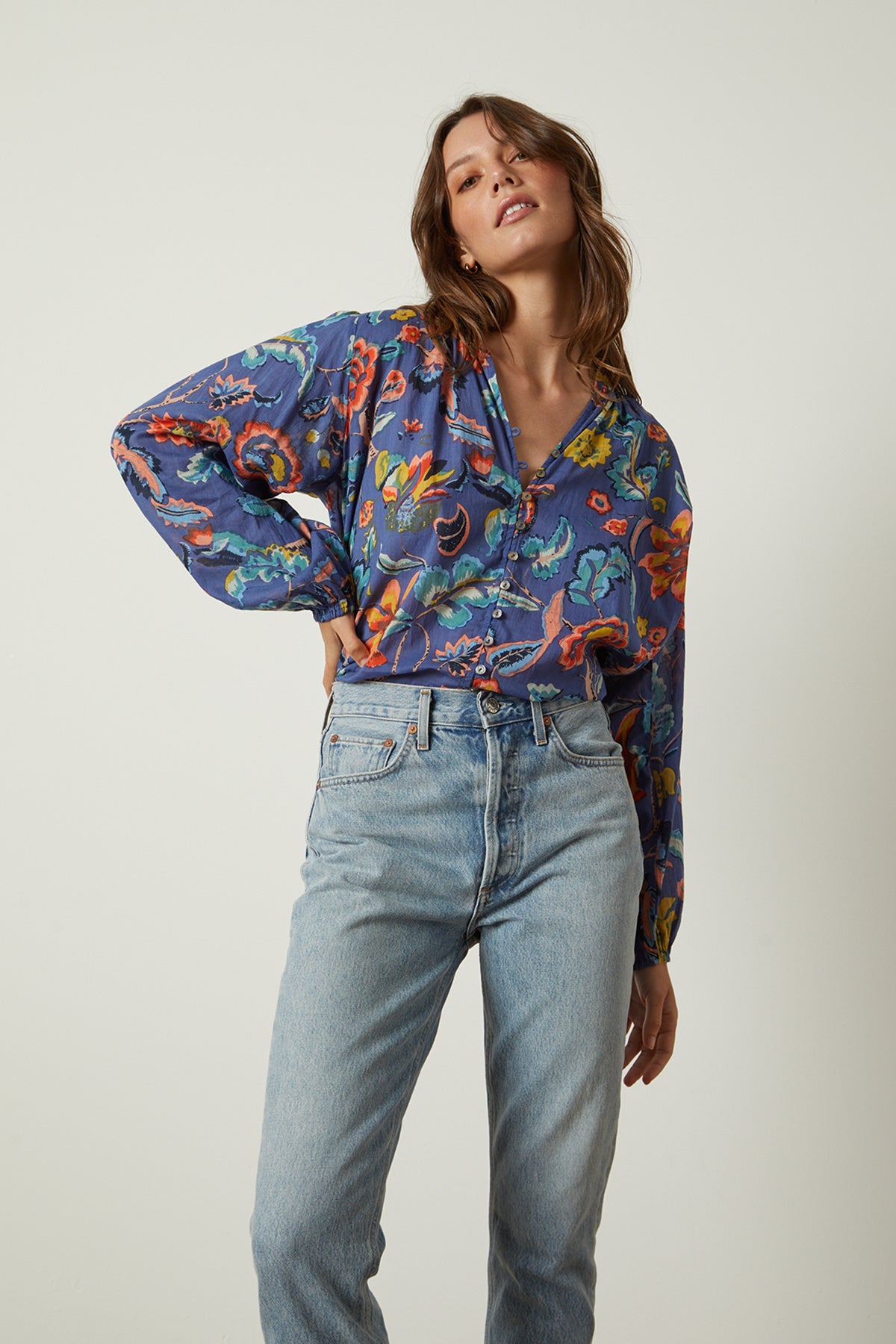   Camryn Top in colorful spring floral print tucked into blue denim front 
