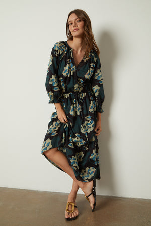 a woman wearing a DENISE PRINTED COTTON LACE DRESS by Velvet by Graham & Spencer and sandals.