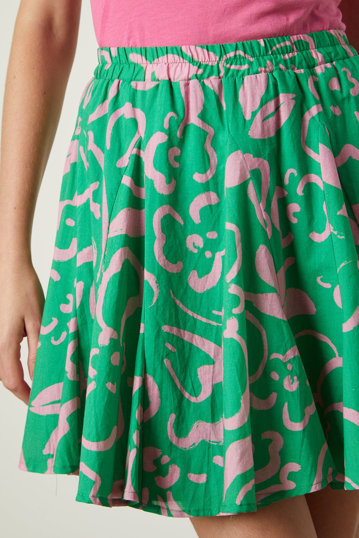 A woman wearing a Velvet by Graham & Spencer ELSA PRINTED SKIRT in green and pink.-25954409545921