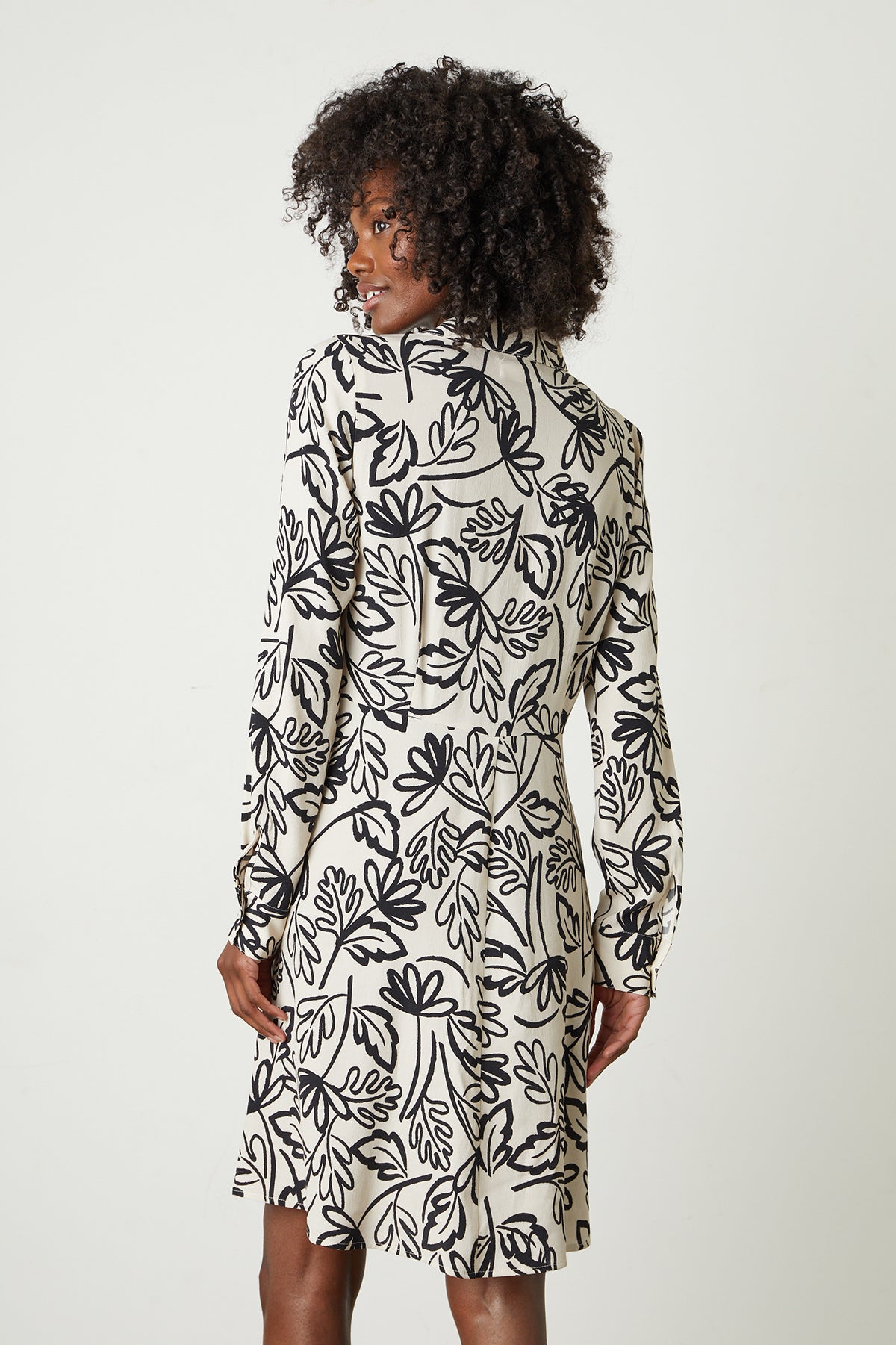   The back view of a woman wearing a Velvet by Graham & Spencer STEPHIE PRINTED CREPE DRESS. 